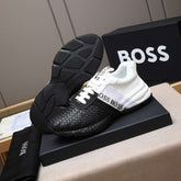 Black and white sneakers with 'BOSS' branding on a black box against a gray background.